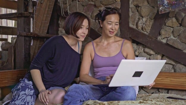 A woman using a CAF (Caisse d'Allocations Familiales) online simulator on her laptop, with a look of concentration and hope, searching for eligible family benefits.