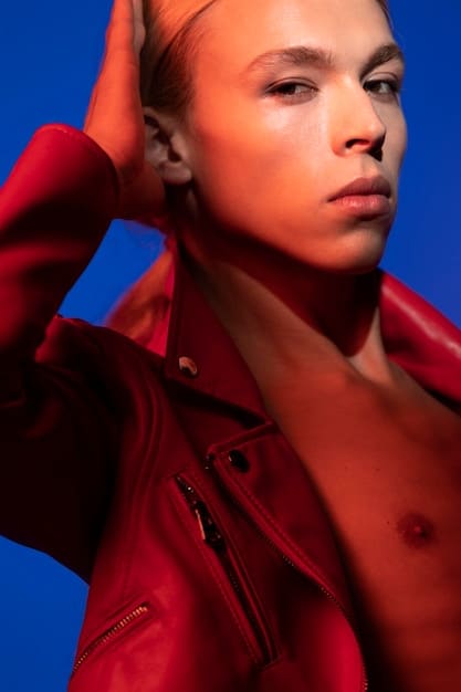A close-up shot of a model wearing a jacket with exaggerated, oversized shoulders. The jacket is made of a textured fabric in a deep burgundy color. Focus on the detailing of the shoulder pads and the overall silhouette.
