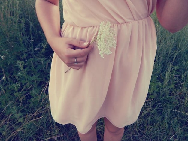 A close-up shot of a pastel-colored outfit. The outfit features light pink dress with a pale yellow cardigan and blue accessories, showing various pastel colors. The background is a soft, diffused light studio setting.
