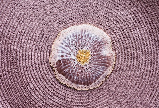 Close-up of a hand touching a fabric made from recycled ocean plastic. The fabric has a subtle texture and is dyed in a natural, earthy tone.