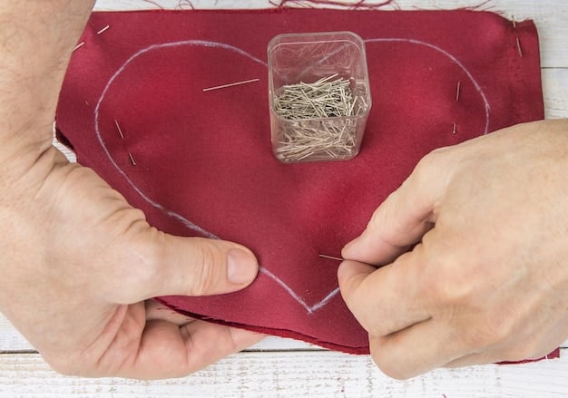 A person's hands mending a small hole on a cotton shirt using a needle and thread. The image shows detailed handcraft work and sustainable clothing practice.