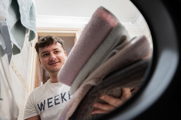 A person carefully loading clothes into a washing machine, with a focus on not overfilling the drum. The shot illustrates the correct amount of space to leave for effective washing.