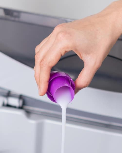 Close-up of a hand pouring a small amount of gentle laundry detergent into a washing machine dispenser, highlighting the importance of choosing the right detergent for delicate clothes.