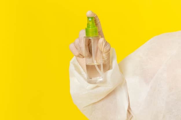 A close-up shot of a hand carefully spraying a protective coating on a set of Shein earrings laid out on a clean surface, with the spray bottle clearly visible.