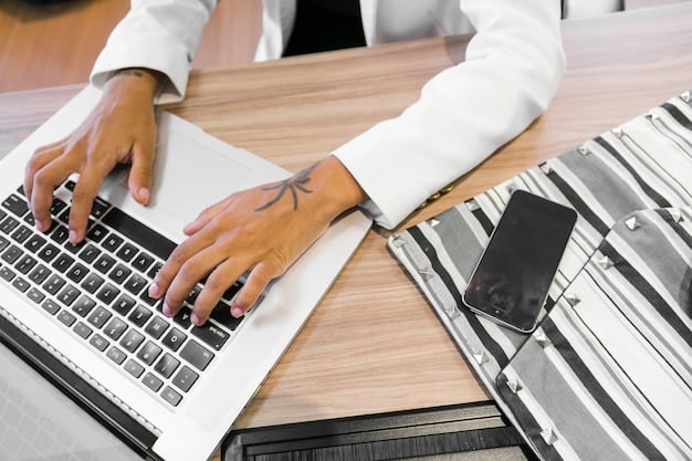 Hands typing on a laptop in a modern office setting, focusing on the fingers and keyboard.The background includes a blurred office environment with soft lighting and other coworkers.The image conveys a sense of work, productivity, and technology.