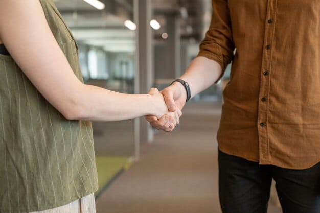 A close-up shot of two hands clasped together in a handshake, signifying a strong professional relationship. The background is blurred, suggesting a busy networking event in Quebec City, Quebec.