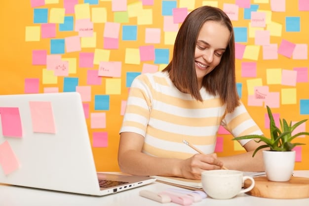 A student happily researching careers on a laptop with sticky notes of ideas all around the laptop on the desk
