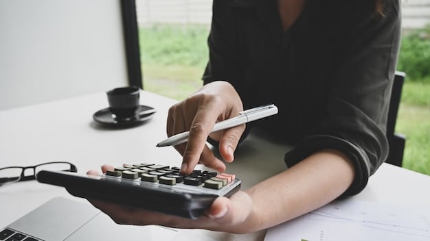 A person using a calculator and reviewing income statements, indicating careful financial planning and awareness of income limits while receiving unemployment benefits.