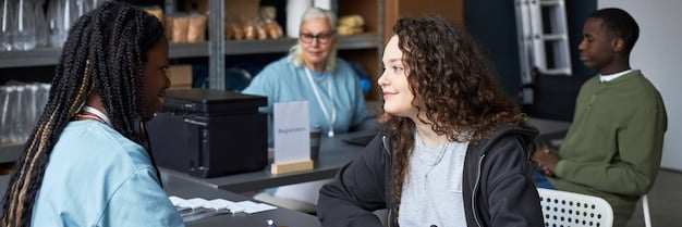 A student smiling confidently while discussing career options with a guidance counselor in a school office. Posters of various universities and career paths are visible in the background.