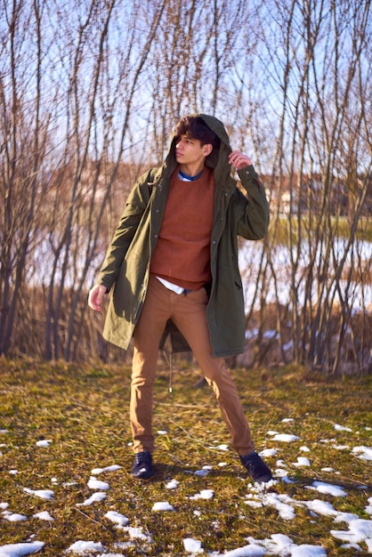 A person wearing a layered fall outfit. The outfit could consist of a basic t-shirt, a flannel shirt, a denim jacket, and a scarf. The setting should be an outdoor fall setting with colorful leaves and soft lighting. The focus is on demonstrating how different pieces can be combined to create a stylish and functional fall look.