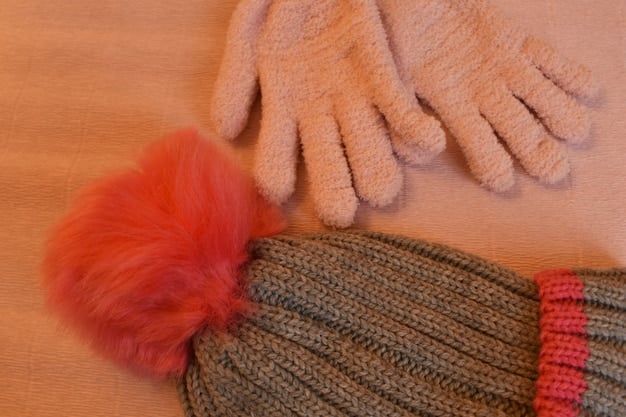 A close-up of various winter accessories, including colorful beanies, knitted gloves and mittens, and stylish scarves in different patterns and textures. The accessories are arranged on a wooden table with a cozy, wintery background.