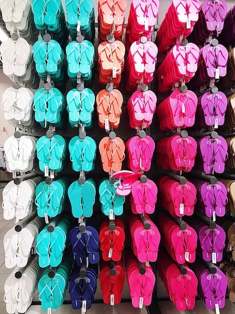 A collection of affordable summer outfits displayed on a rack, featuring sundresses, shorts, tank tops, and sandals, all in bright and summery colors.