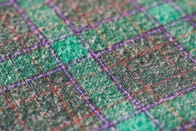 A close-up of a computer screen showcasing AI software identifying defects in a piece of fabric, with highlighted areas indicating specific flaws like tears or uneven stitching.
