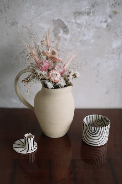 A close-up of various Shein home decor items, including a ceramic vase, a decorative candle, and a small faux plant, showcasing the detailed textures and designs.