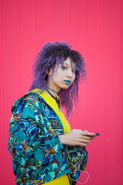 A model wearing a Shein outfit featuring a mix of bold colors and expressive prints, such as a neon pink top with a geometric pattern skirt. The background is a bright, colorful graffiti wall.