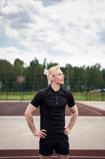 A man wearing Shein activewear, consisting of a compression shirt and running shorts, jogging on a track with a determined expression.