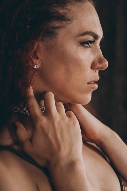 A close-up shot of a woman wearing a delicate gold necklace and a pair of small hoop earrings from Shein. The lighting is soft and highlights the sparkle of the jewelry.