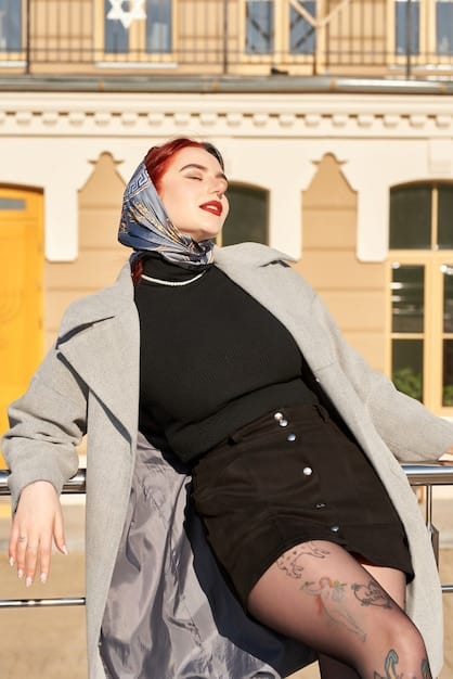 A woman wearing a Shein scarf tied in a Parisian knot. She's wearing a black trench coat and the scarf adds a pop of color and sophistication to her outfit.