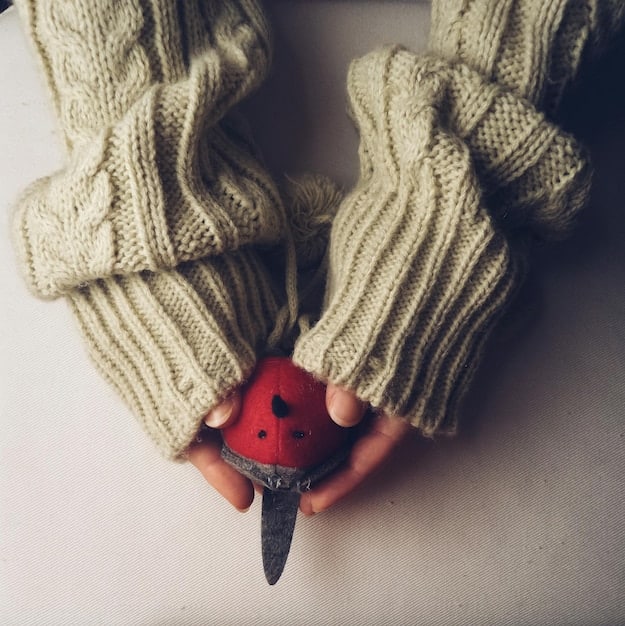A person hands touching different winter coat material, woolen and polyester.